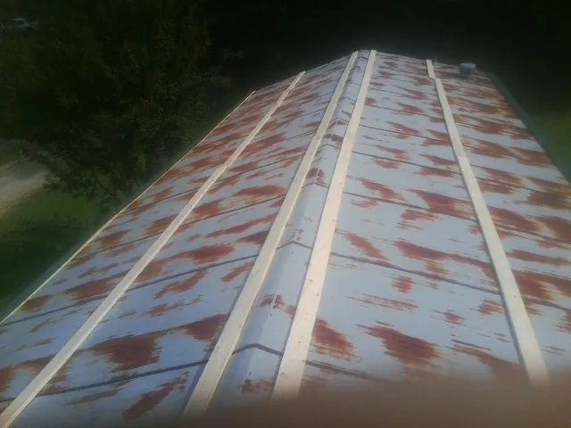 Rusted metal roof panels with new wood purlins before replacement — Storm Damage Roof Repair in Troy by Roofing Brothers